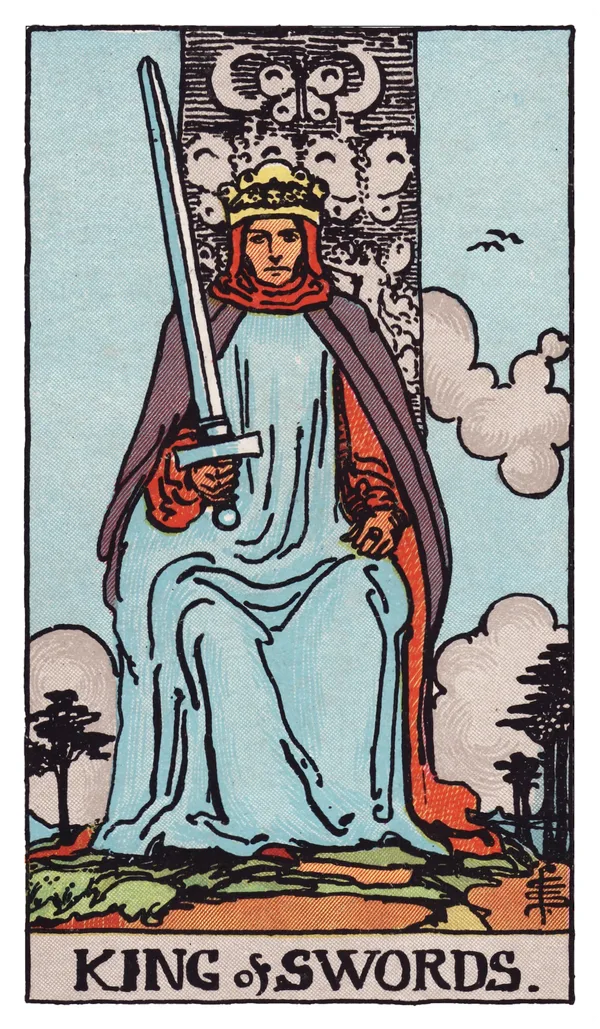 The King of Swords from the Rider-Waite-Smith deck: a king sits facing forward on a throne carved with butterflies and a crescent moon, holding an upright sword steadily in one hand, two birds flying in the sky behind him, distant mountains and bare trees stretching across the horizon.