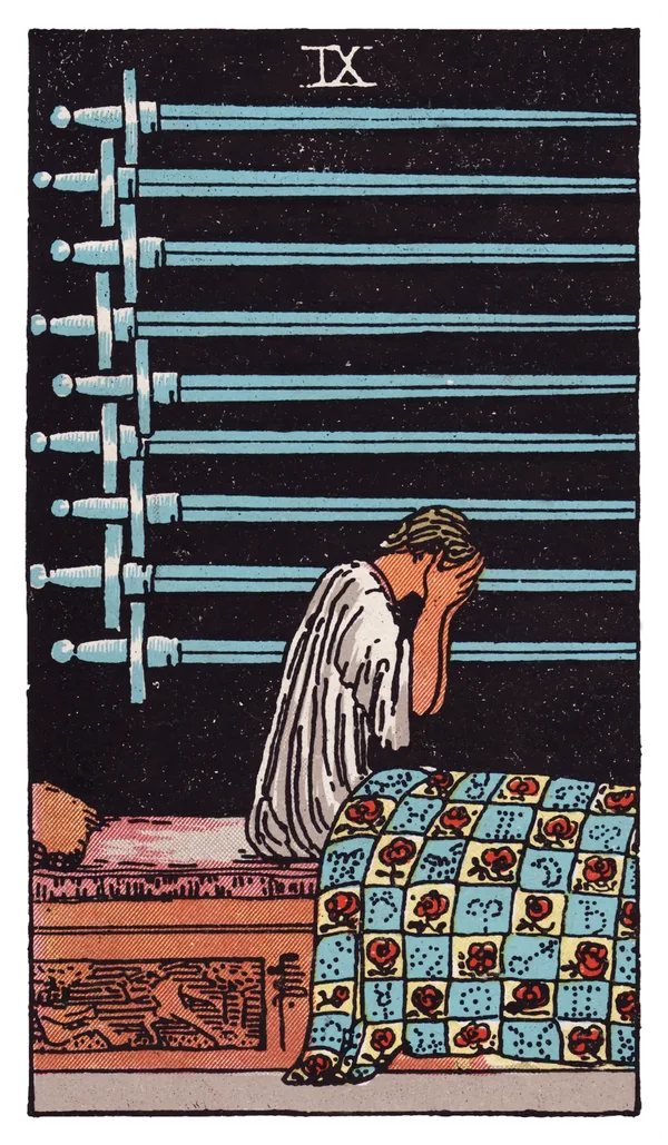 The Nine of Swords from the Rider-Waite-Smith deck: a figure sits upright in bed at night, head buried in both hands, nine swords mounted horizontally on the dark wall behind them, the quilt below decorated with roses and astrological symbols, a carved panel on the bed showing one figure attacking another.