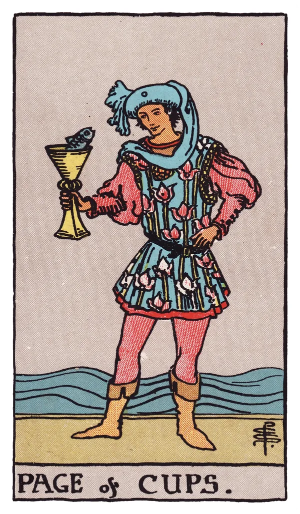 The Page of Cups from the Rider-Waite-Smith deck: a young figure in a flowing, flower-patterned tunic stands at the water's edge, holding up a golden cup from which a fish pops its head out; the figure gazes at the fish with open curiosity, waves rolling gently behind.