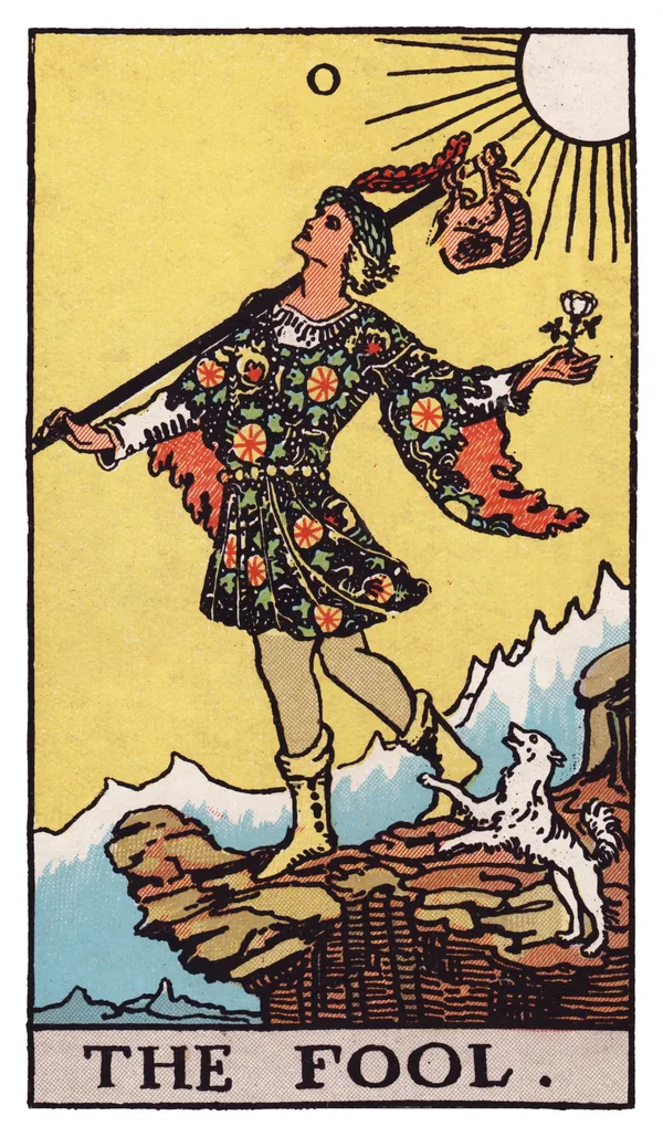 The Fool from the Rider-Waite-Smith deck: a young traveler in bright clothing steps toward a cliff edge with a small white dog at his heels, a bindle on a stick over his shoulder, facing a sunlit mountain range, apparently unaware of the drop just ahead.