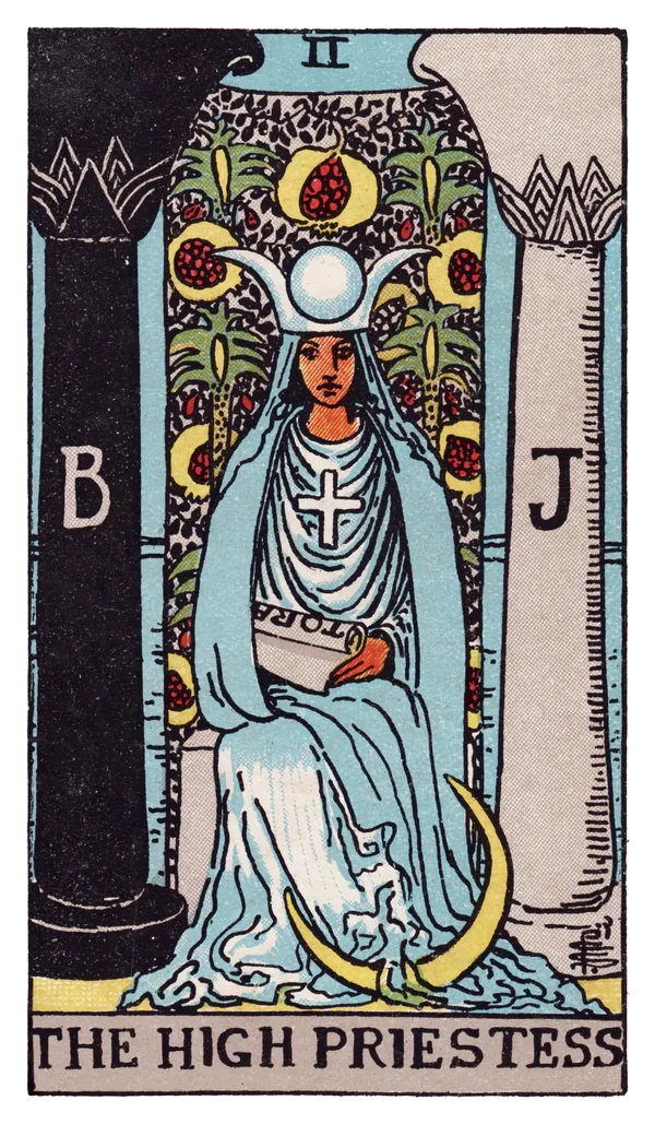 The High Priestess from the Rider-Waite-Smith deck: a robed woman sits enthroned between two pillars marked B and J (Boaz and Jachin), a veil embroidered with pomegranates hanging behind her, a crescent moon resting at her feet, a horned lunar headdress with a solar disc crowning her head, a solar cross on her chest, and a partially-hidden scroll marked TORA resting in her lap.